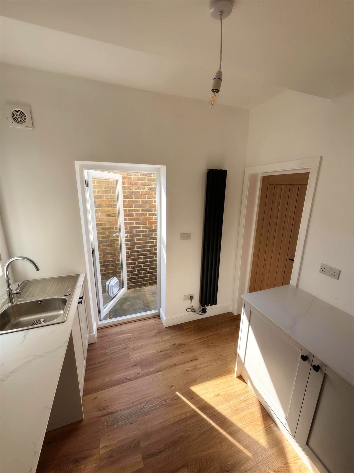 Garage converted into a utility room with sink and cupboards, Hove