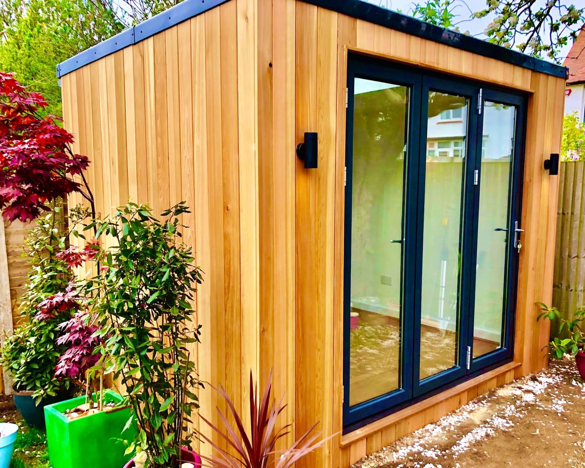 Cedar garden office with bi-fold doors and planting in Worthing