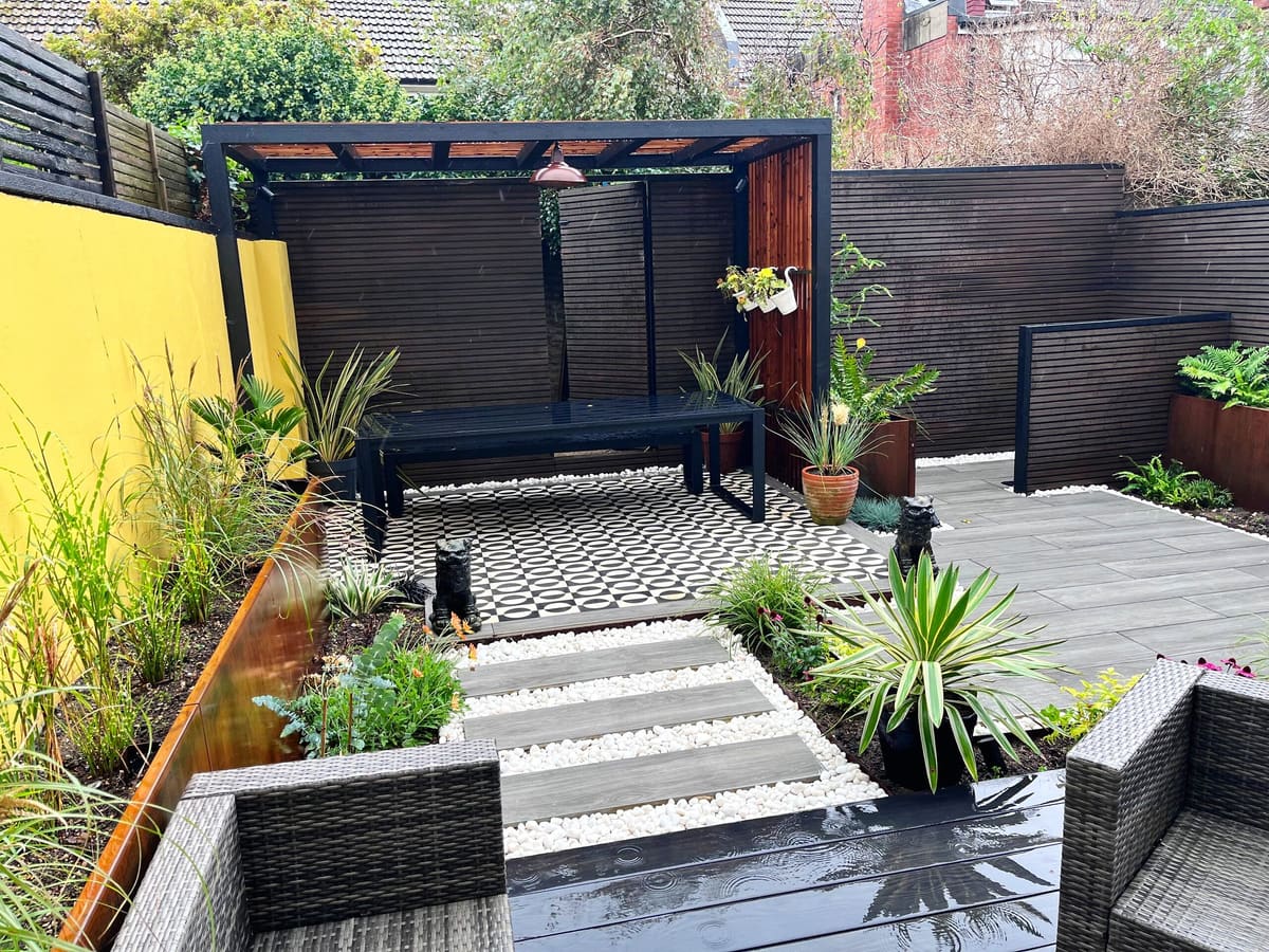 Decked courtyard with pergola, bench and planting
