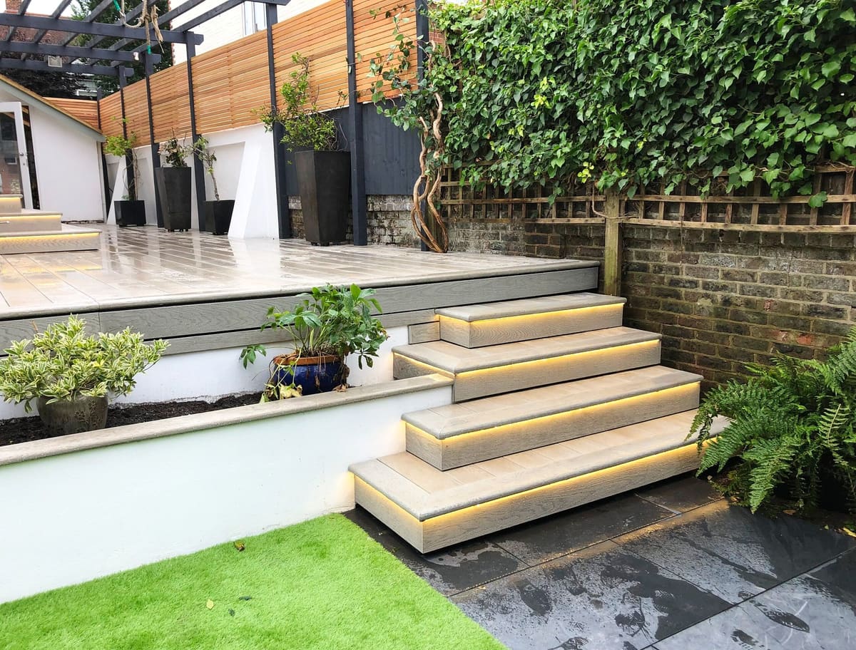 Raised porcelain terrace with lit steps and planting