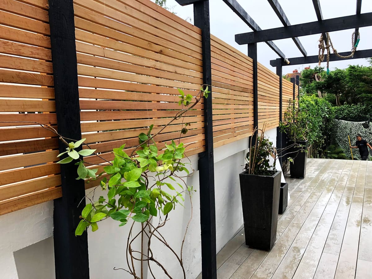 Slatted cedar screen fencing and planting along a deck